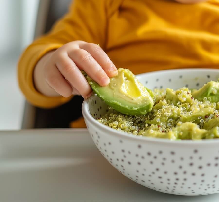 Toddler eating a meal with avocado