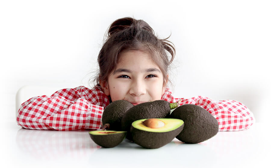 girl with avocados on table