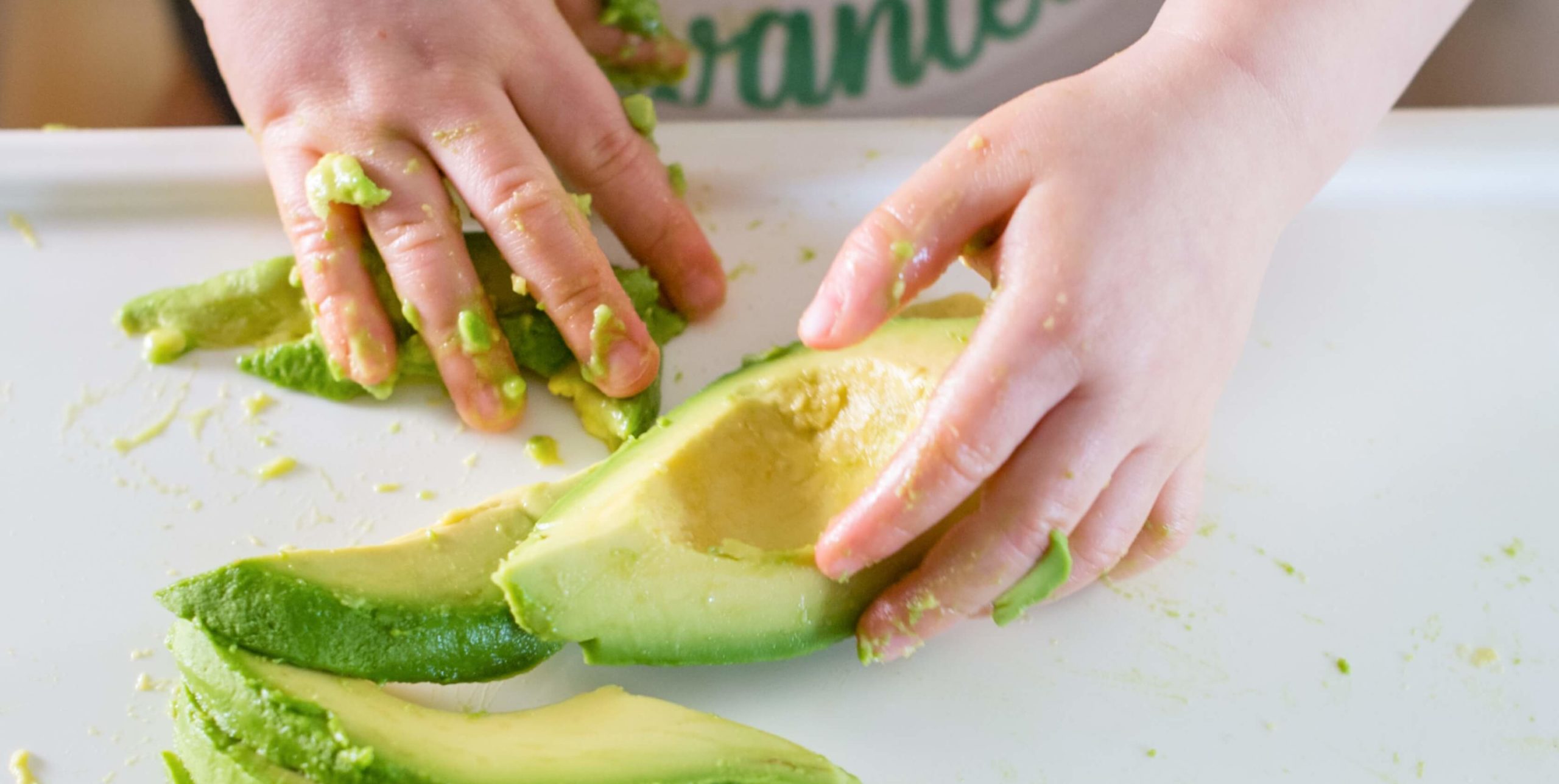 Toddler reaching for avocado
