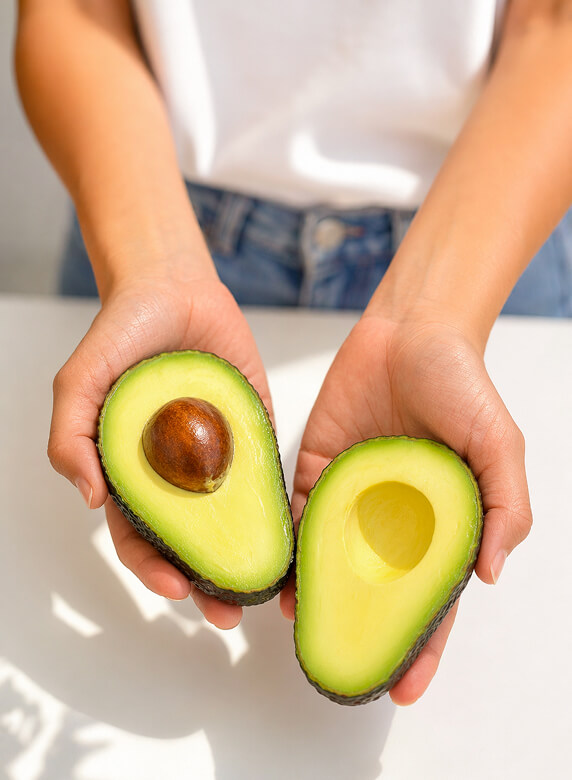 hands holding avocados