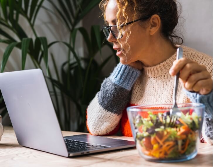 woman eating while working