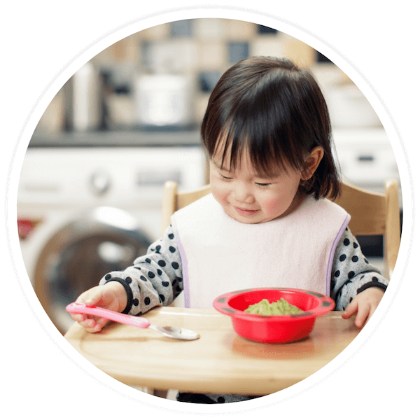 toddler eating mashed avocado
