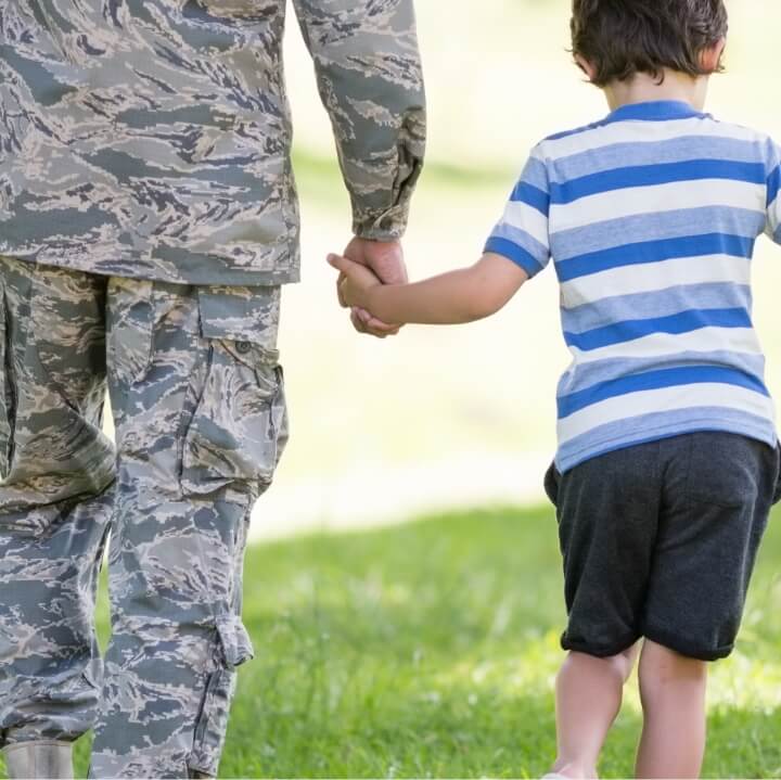 veteran holding a childs hand